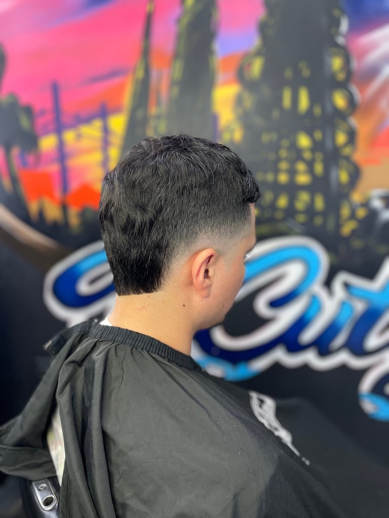 Back view of a person with a short dark fade haircut wearing a black shirt against a colorful city skyline mural